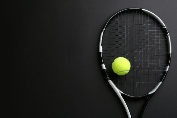 Picture of Tennis racket and ball on black background