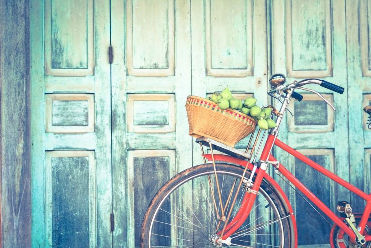 Bild på Hipster red bicycle in old building walls background  color if vintage tone 