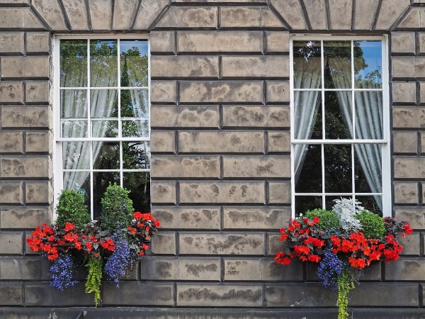 Afbeeldingen van Old stone house with colorful window flowers Edinburgh