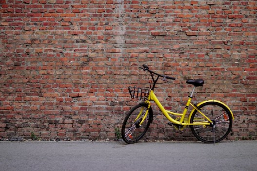 Bild på Yellow Bicycle by the Brick Wall