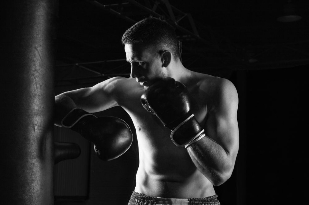 Afbeeldingen van The fighter of mixed martial arts beats on the bag with his elbow
