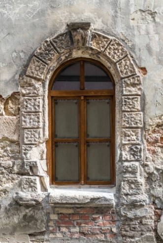 Afbeeldingen van Old window on ancient wall