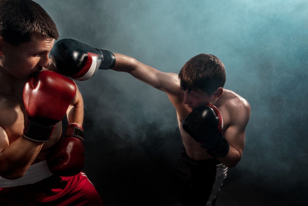 Afbeeldingen van Two professional boxer boxing on black smoky background
