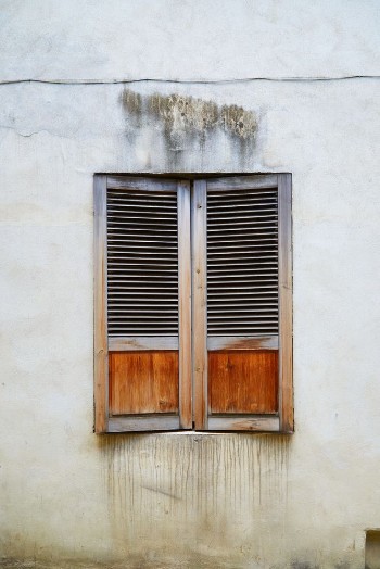 Bild på The old window covered with wooden shutters in the old town in Riga