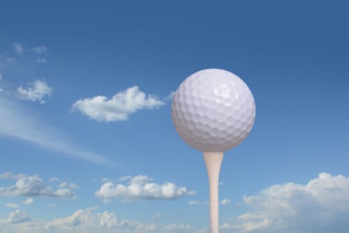 Afbeeldingen van Golf ball on golf tee blue sky background