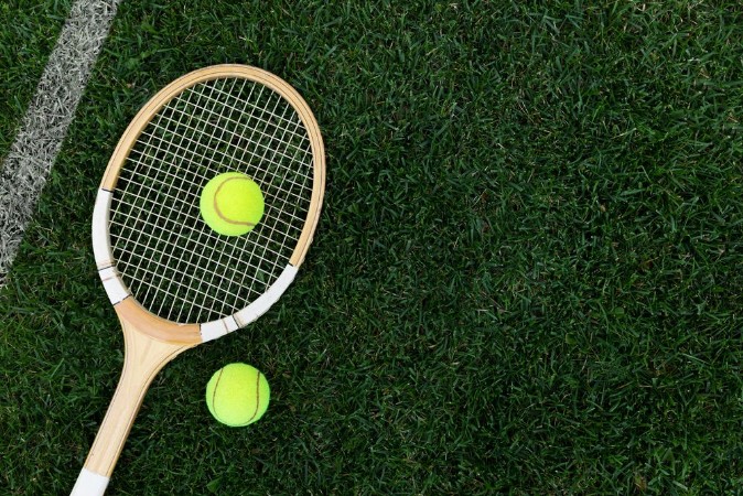 Afbeeldingen van Retro tennis racket on natural grass with balls top view with copy space