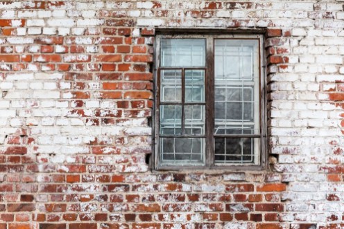 Picture of Wooden window on weathered red brick wall painted white