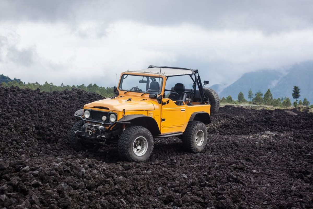 Picture of Offroad yelow vehicle parked at the top of a valley with volcanic rock and mountains in Bali Indonesia