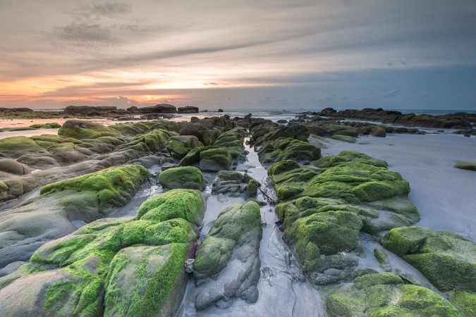 Bild på Colorful sunset with natural coastal rocks Image contain soft focus due to long exposure