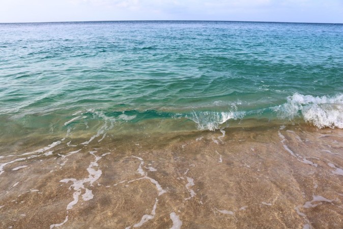 Picture of Close up of a wave of crystal clear water crushing on the shore of a beach on the island of Principe