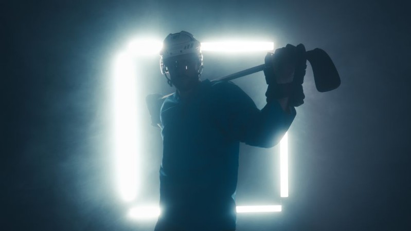 Afbeeldingen van Portrait of Caucasian male ice hockey player in uniform looking into the camera dramatic lighting