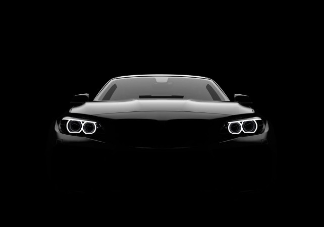 Image de Front view of a generic and brandless modern car on a black background
