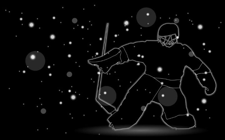 Afbeeldingen van Hockey player silhouette on black background with bokeh effect