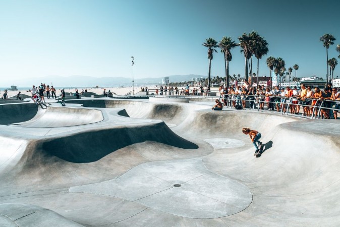Bild på June 10 2018 Los Angeles USA Venice beach skate park by the ocean People skating at the skatepark showing different tricks 