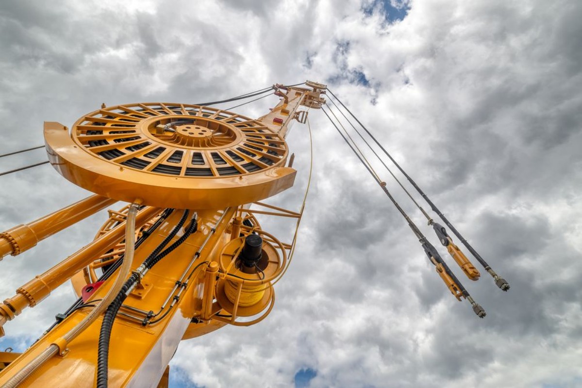 Image de The boom of a drilling machine and a crane against the sky