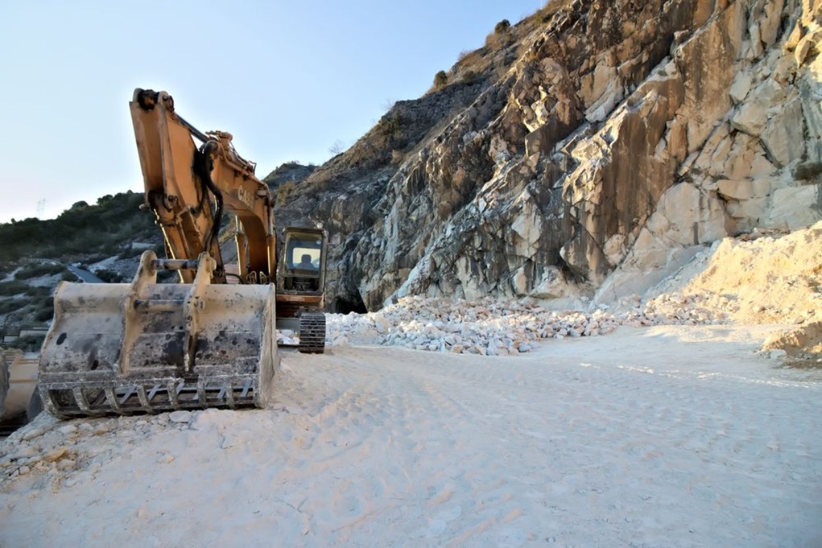 Bild på Apuan Alps Carrara Tuscany Italy  An excavator in a quarry of white Carrara marble In the mountains of the Apuan Alps above the city of Carrara white marble has been mined since Roman times 