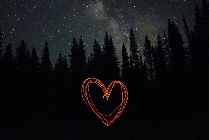 Picture of Heart made with glowing embers while camping below starry sky