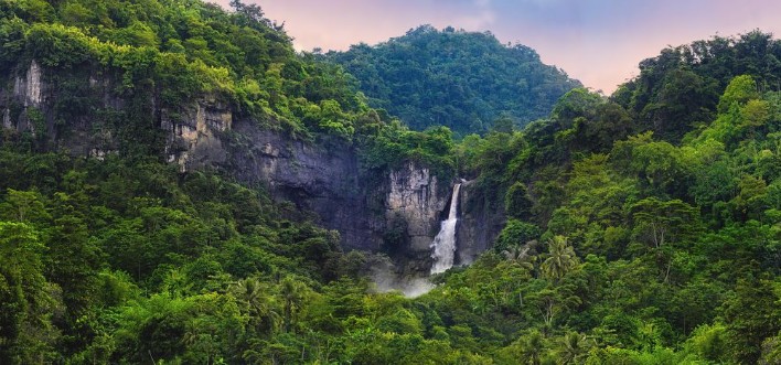 Bild på Wonderful Landscape of Cascade Waterfall in Tropical Rainforest Scenery of Rocky Cliff and Cimarinjung Waterfall at UNESCO Global Geopark Ciletuh