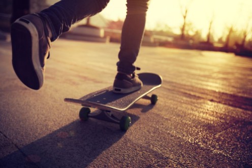 Afbeeldingen van Skateboarder skateboarding at sunrise city