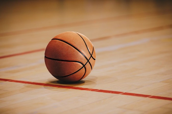 Image de Classic Basketball on Wooden Court Floor Close Up with Blurred Arena in Background Orange Ball on a Hardwood Basketball Court