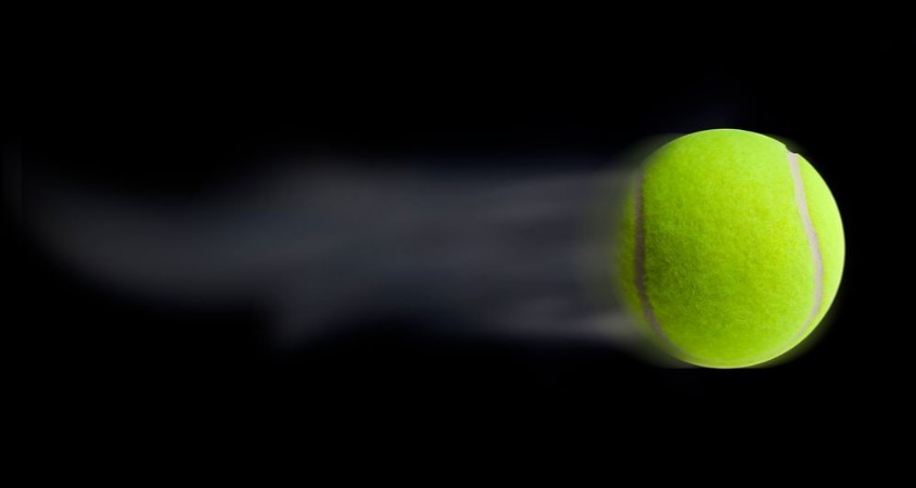Afbeeldingen van Tennis ball fast moving on black background