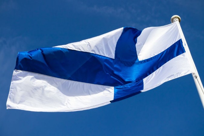 Picture of Finnish national flag on the wind against the blue sky