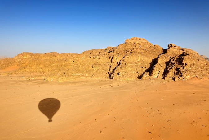 Afbeeldingen van Shadow of hot-air balloon over the desert of Wadi Rum