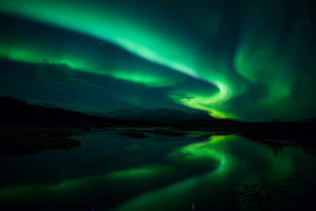 Afbeeldingen van Northern lights above lagoon in Iceland