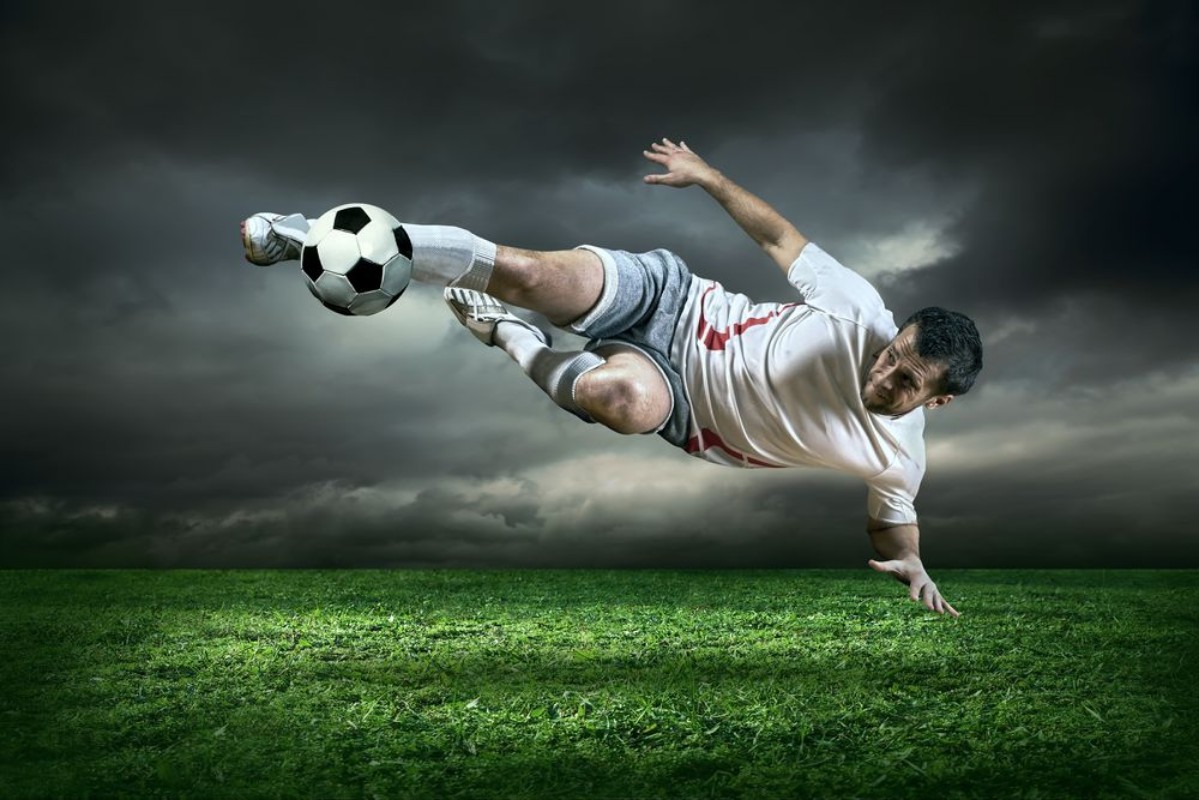 Afbeeldingen van Football player with ball in action under rain outdoors