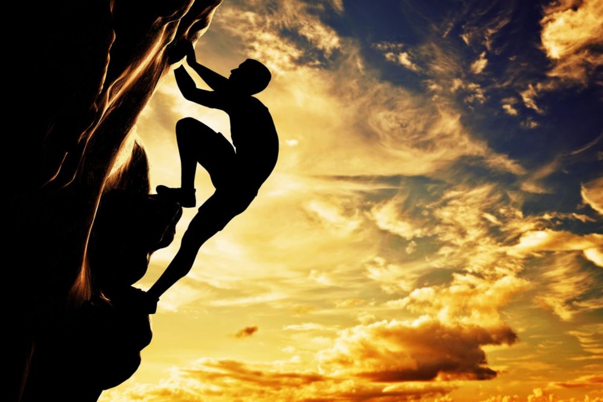 Afbeeldingen van A silhouette of man climbing on mountain at sunset Adrenaline