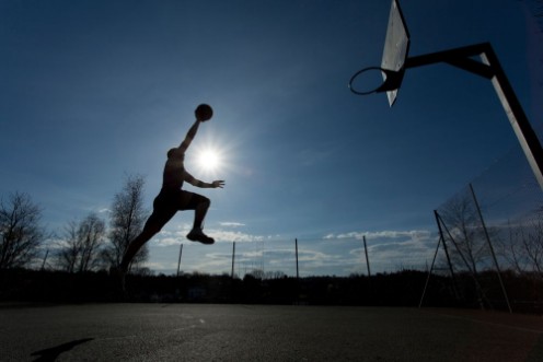 Afbeeldingen van Basketball player silhouette taking off to slam dunk
