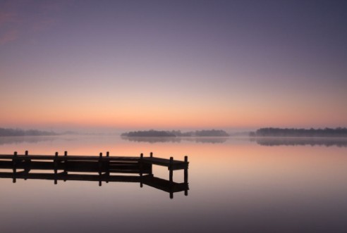 Afbeeldingen van Jetty at a lake during a tranquil foggy dawn