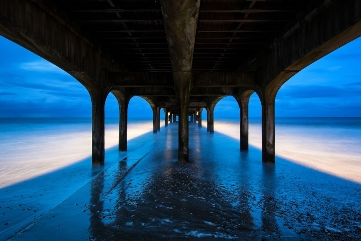 Picture of Twilight dusk landscape of pier stretching out into sea with moo