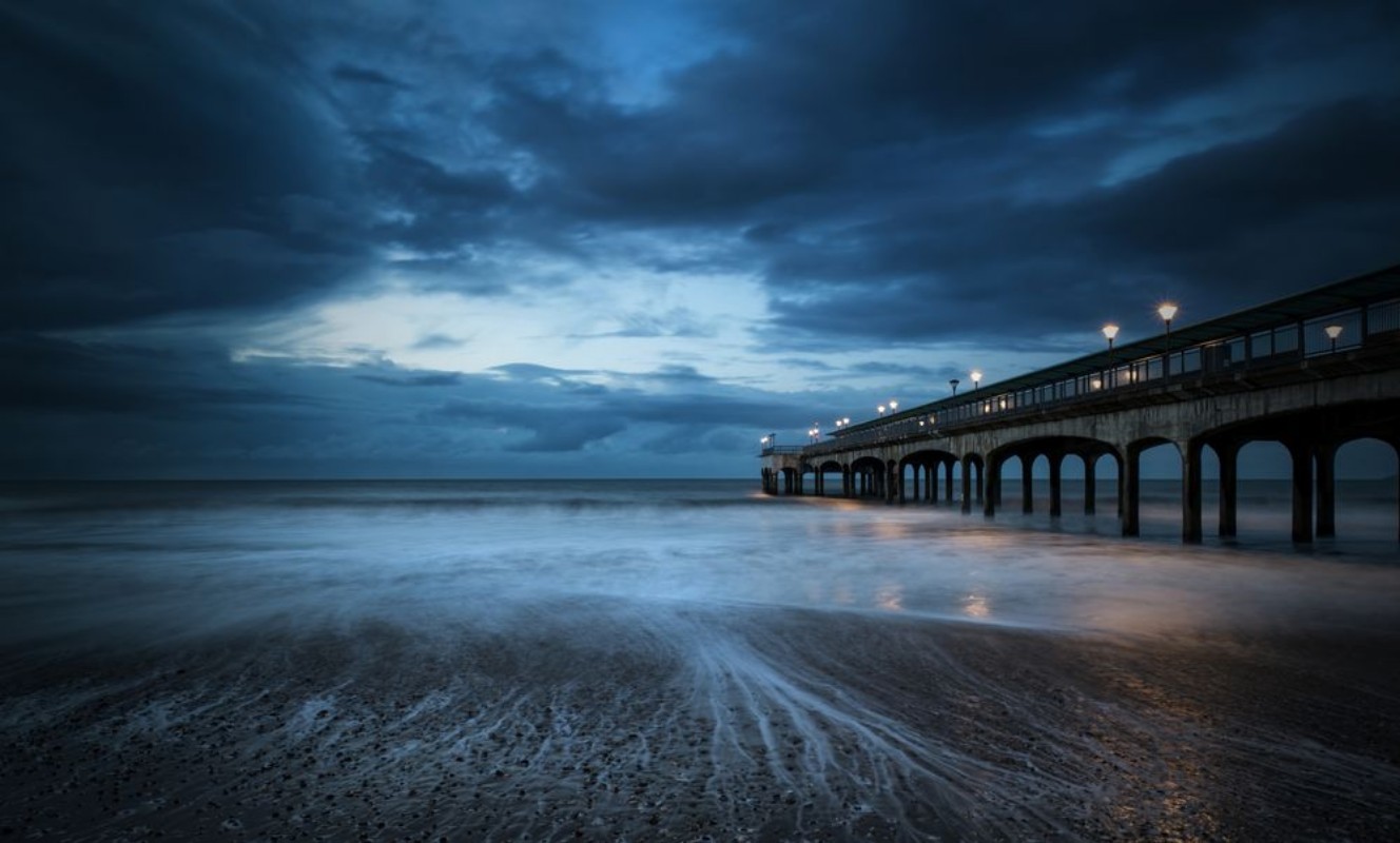 Image de Twilight dusk landscape of pier stretching out into sea with moo
