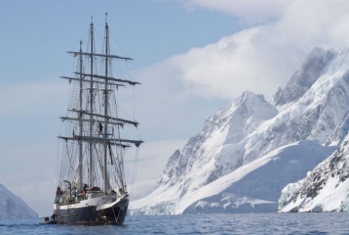 Bild på Tourist ship sailing summer day on a background of mountain peak