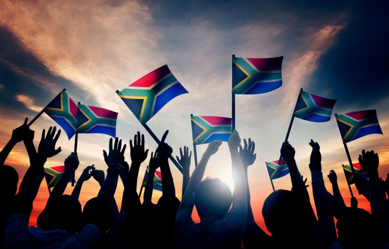 Afbeeldingen van People Waving South African Flags in Back Lit