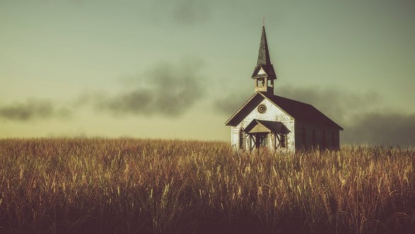 Picture of Old abandoned white wooden chapel on prairie at sunset with clou