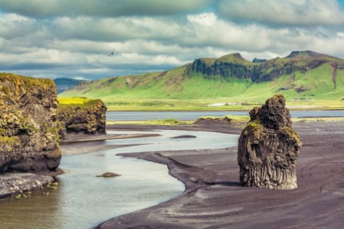 Afbeeldingen van The black sand beach with typical Icelandic mountain landscapes