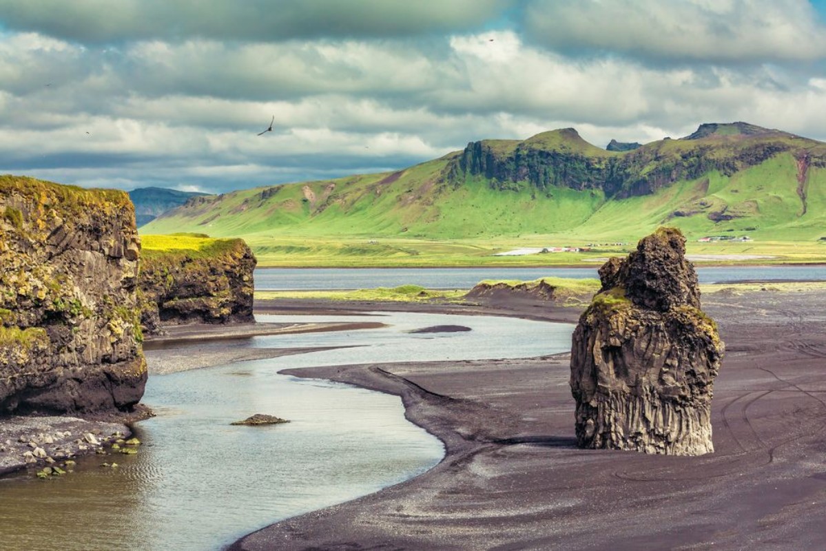 Bild på The black sand beach with typical Icelandic mountain landscapes