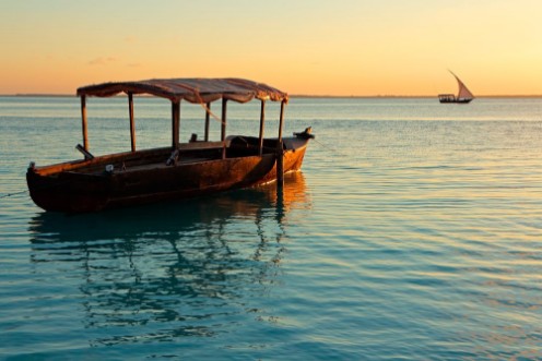 Afbeeldingen van Wooden boat on water at sunset Zanzibar island