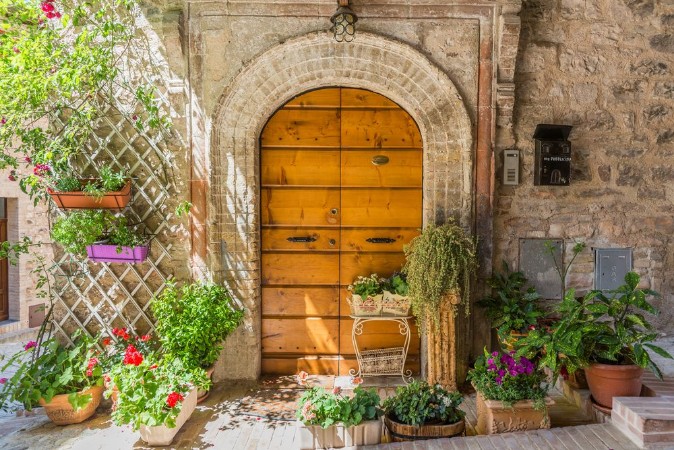 Bild på Elegante porta di legno con vasi di fiori