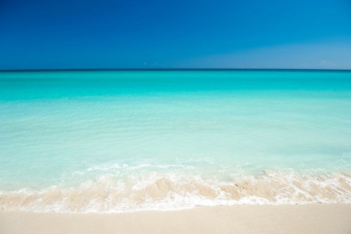 Bild på Shore of classic turquoise Caribbean Sea dream beach under bright blue sky in Varadero Cuba