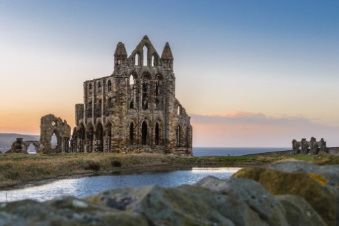 Bild på Stone ruins of Whitby Abbey on the cliffs of Whitby North Yorkshire England at sunset
