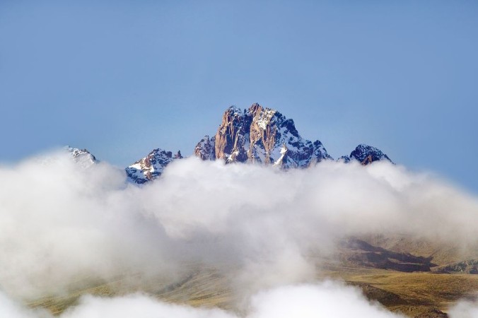 Bild på Aerial of Mount Kenya Africa with snow and white puffy clouds in January the second highest mountain at 17058 feet or 5199 Meters