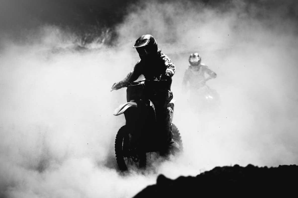 Picture of Motocross racer accelerating in dust track Black and white hig
