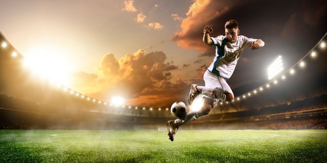 Afbeeldingen van Soccer player in action on sunset stadium panorama background