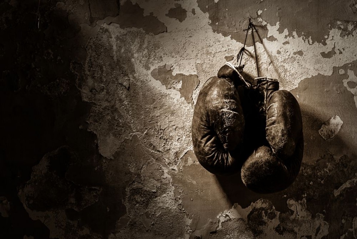 Bild på Old boxing gloves hang on nail on texture wall